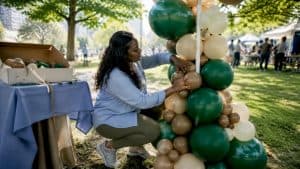 Balloon artist setting up vibrant balloon column outdoors