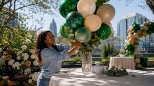 Woman arranging baby shower balloon centerpiece