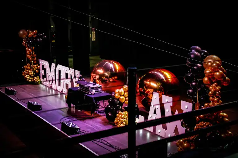 Atlanta Balloon Designer - Luxury corporate event decor for Emory Law Barrister's Ball featuring illuminated marquee letters spelling EMORY LAW, large reflective PVC mirror balls, metallic balloon towers on gold stands, and elegant balloon clusters on stage.