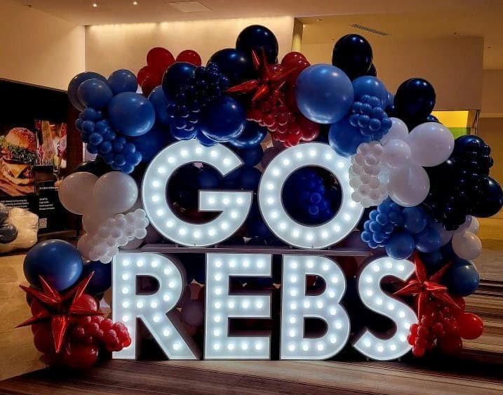 Balloon Decor Pricing 57 Illuminated GO REBS for Ol' Miss rchampion reception at the Marriott Marquis, 4 ft marquee letters stacked , surrounded by custom balloon wall,colors red, white, and blue balloon decorations for a university celebration and school spirit event. Atlanta Balloon Designer created this custom event display featuring premium balloon décor designed for graduations, college University events, athletic celebrations, Grad event, proms, and campus activations. We provide balloon arches, balloon columns, custom backdrops, marquee letters, event rentals,balloon garlands, corporate décor, and professional event styling across Metro Atlanta.
